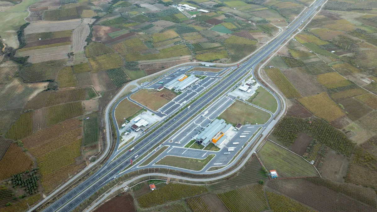 Tarlaların arasından geçen otoyol ve iki yanındaki dinlenme tesisleri, havadan görünüm