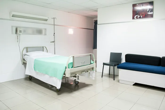 Hastane odasında yatak, serum askısı, sandalye ve refakatçi koltuğu