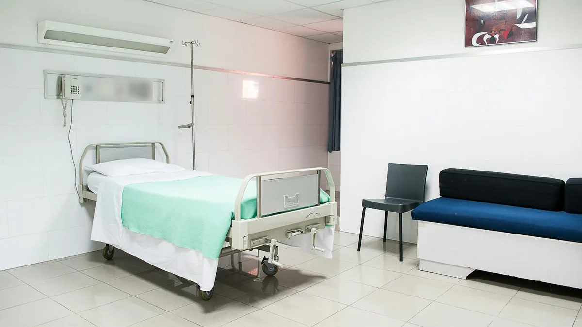 Hastane odasında yatak, serum askısı, sandalye ve refakatçi koltuğu
